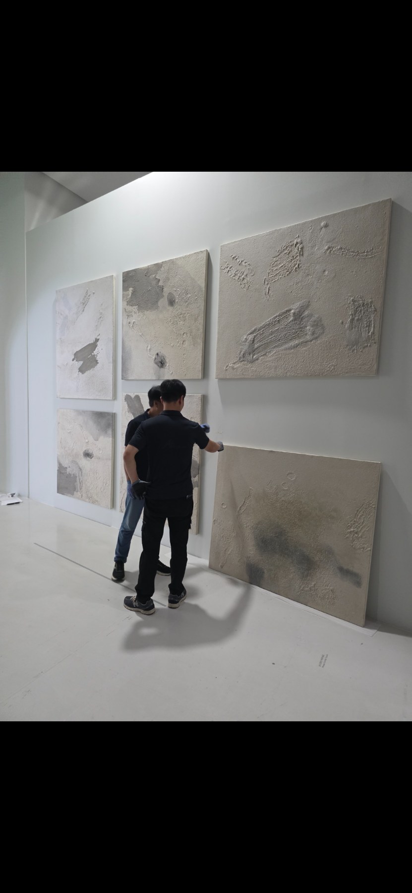 Two art handlers installing artwork